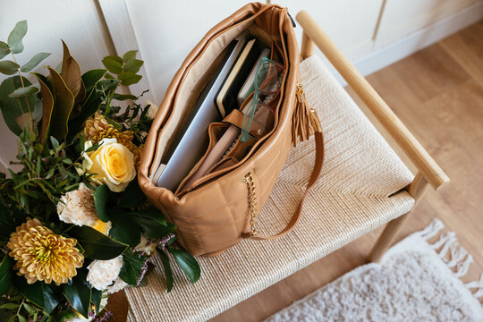 Bouquet of flowers and handbag on chair