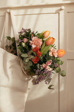 Bouquet of fresh flowers in textile bag