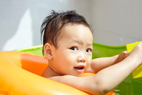 Asian kid playing in small swimming pool

