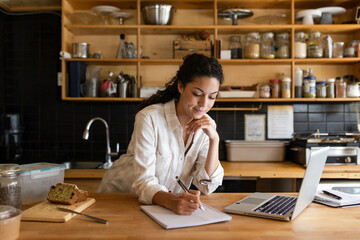 Cafe Owner Taking Notes In Kitchen