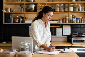 Cafe Owner Taking Notes In Kitchen