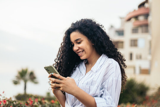 Young woman smiling using the smartphone