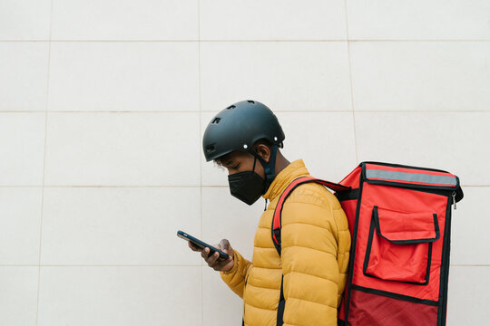 Delivery man using smartphone during pandemic