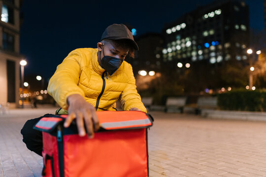 Courier in mask preparing for delivering orders