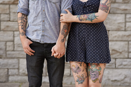 Their bodies are the pages to their love story. Cropped shot of a couple with tattoos on their bodies.