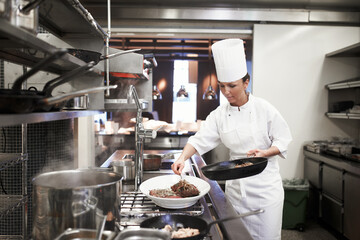 Eating is necessary but cooking is an art. Shot of chefs preparing a meal service in a professional...