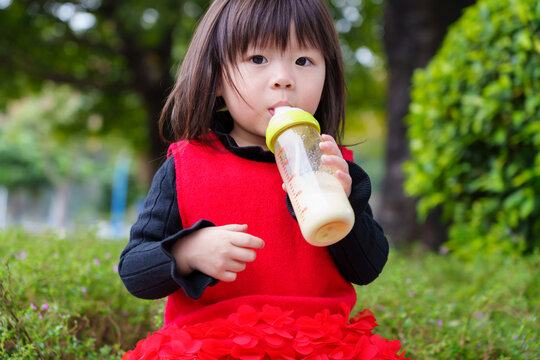 Asian Kid Drinking Milk Outdoors