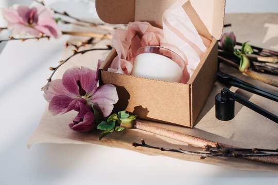 Gift box with soy wax candle and flowers around 