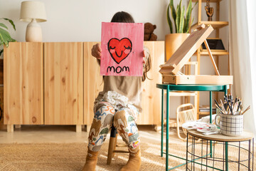 Kid showing drawing for mom at camera