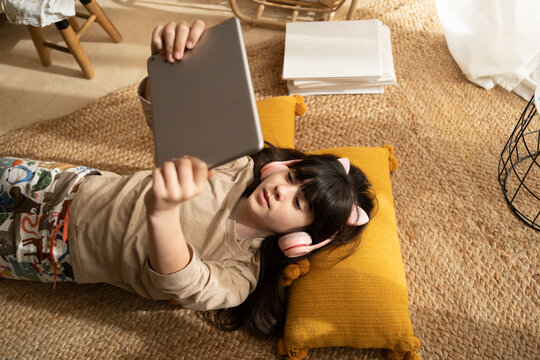 Girl watching tablet at living room floor