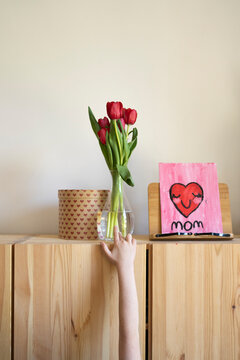 Kid's hand showing gifts on furniture for mother's day