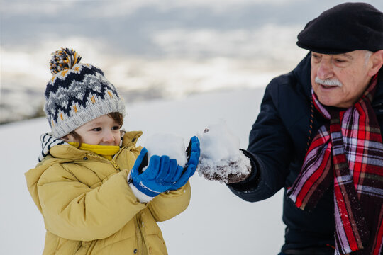 Grandpa And Grandson having fun on the snow