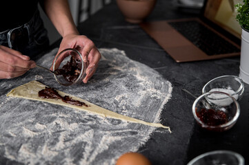 Crop woman cooking chocolate croissant