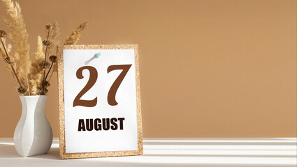 august 27. 27th day of month, calendar date.White vase with dead wood next to cork board with numbers. White-beige background with striped shadow. Concept of day of year, time planner, summer month