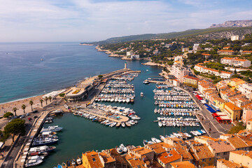 Naklejka na ściany i meble Picturesque aerial view of Cassis cityscape on Mediterranean coast with marina on sunny autumn day, Southern France.