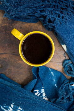 Yellow Cup Of Coffee On A Wooden Base