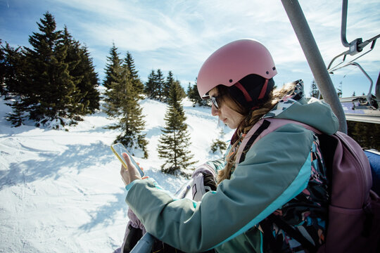 Woman using the phone on the ski lift
