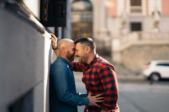 Loving couple of homosexual men embracing in city
