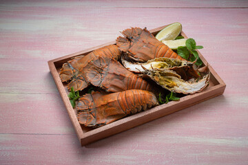 Flathead lobster on wooden background, Flathead lobster or Mantis shrimp on wooden plate ready to...