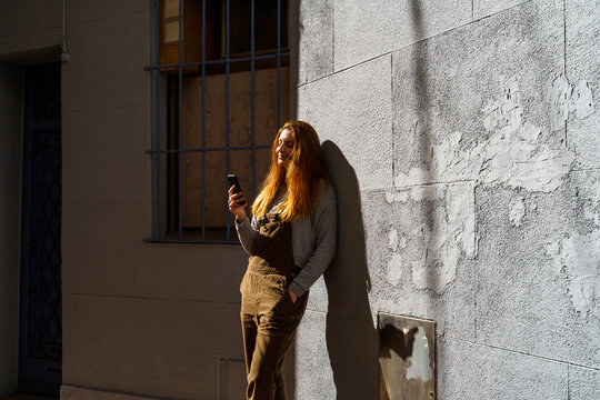 Young happy woman using phone in the city