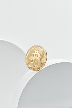Golden bitcoin balancing on rim