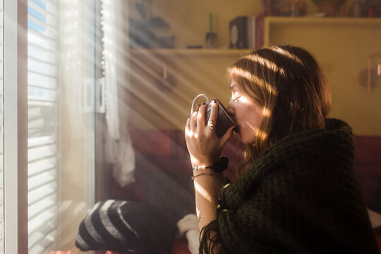 Woman drinking coffee during winter morning 