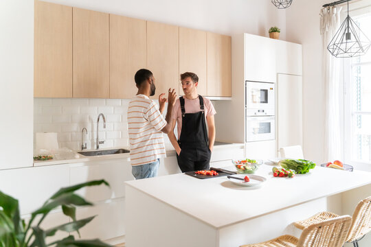 Gay Couple Having Conversation In The Kitchen