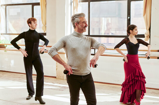 Smiling flamenco teacher leading a class