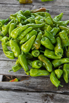 Green chili peppers on a wooden base. 