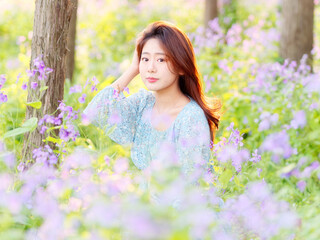 Portrait of elegant Chinese girl in dress enjoy carefree time in forest park in sunny day. Outdoor fashion portrait of glamour young Chinese cheerful stylish woman.