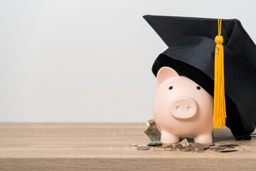 Black graduation hat and piggy bank concept investment in education Graduation save money for education - obrazy, fototapety, plakaty