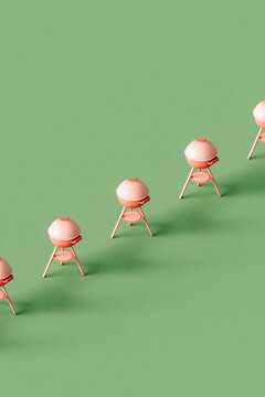 a row of Pink barbeque grill on a green background