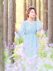 Portrait of elegant Chinese girl in dress enjoy carefree time in forest park in sunny day. Outdoor fashion portrait of glamour young Chinese cheerful stylish woman.