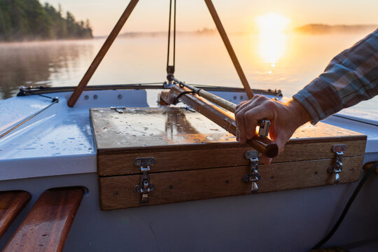 Mahogany Tiller and Teak Lazarette of Dinghy Sailboat At Sunrise