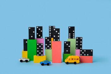 Сolored cubes with domino over it and toy cars near