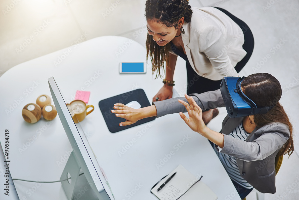 Poster this is unreal. high angle shot of a young businesswoman using a vr headset while being assisted by 