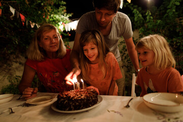 Father is lighting candles on a chocolate cake