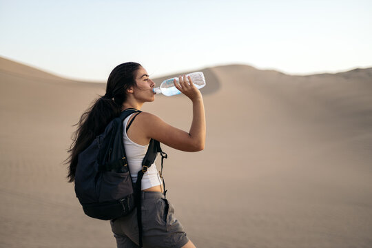 Woman drinking water in the desert