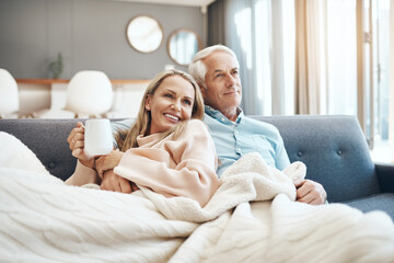 Coffee, couch, comfortability and you is all I need. Cropped shot of a mature couple relaxing on...