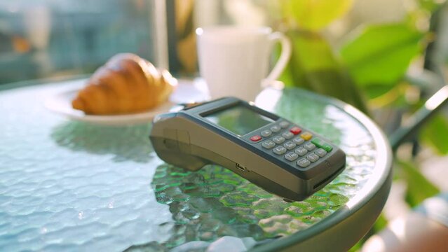 NFC credit card payment. Woman paying with contactless credit card with NFC technology to pay order on bank terminal in a cafe. Wireless money transaction. Wireless payment