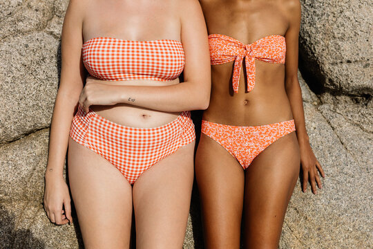 two women of different size and race wearing bikinis