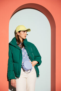 Relaxed female in outerwear leaning on arch