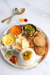 Indian vegetarian Thali or platter includes Aloo ki sabji, dal rice, Puri bhaji, Shrikhand or...