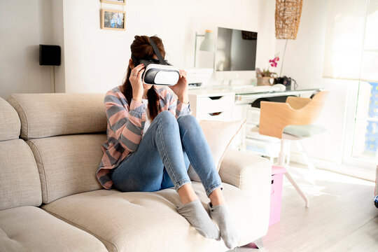 Woman exploring virtual reality in glasses at home