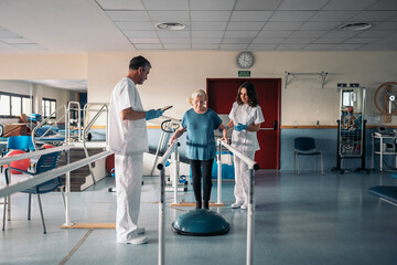 Doctors helping patient during physiotherapy session