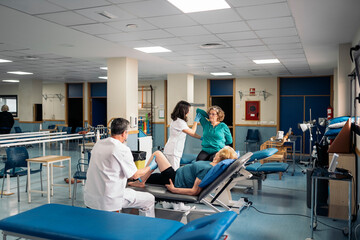 Physiotherapists checking up elderly patients in clinic