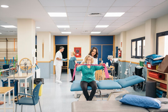 Female physiotherapist checking up mature patient