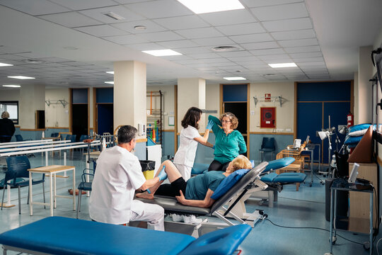 Physiotherapists checking up elderly patients in clinic