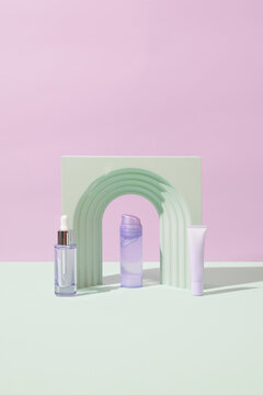 Various Purple Cosmetic Products Against A Pink Green Background