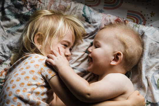 A baby brother strokes his sisters face